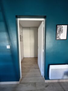 Couloir débarras avec rangements desservant chambre et salle de bain