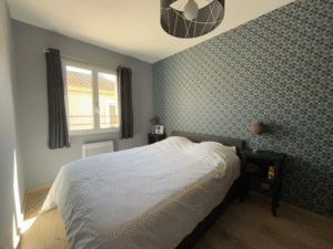 Lit double moderne et confortable avec coffre de rangement et chevets anciens